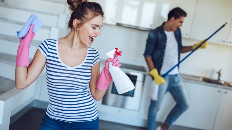 Young happy couple is having fun while doing cleaning at home. - Image 