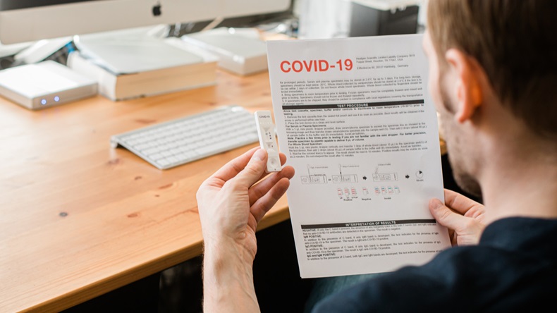 Riga, Latvia - April 8 2020: Coronavirus SARS-CoV-2 testing at home. COVID-19 Rapid test cassette for coronavirus. Man holding a rapid testing kits. Man reading a manual how to do a Test at home