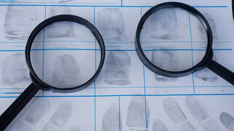 Magnifying glass on fingerprint crime page file.Concept of finding evidence in criminal.