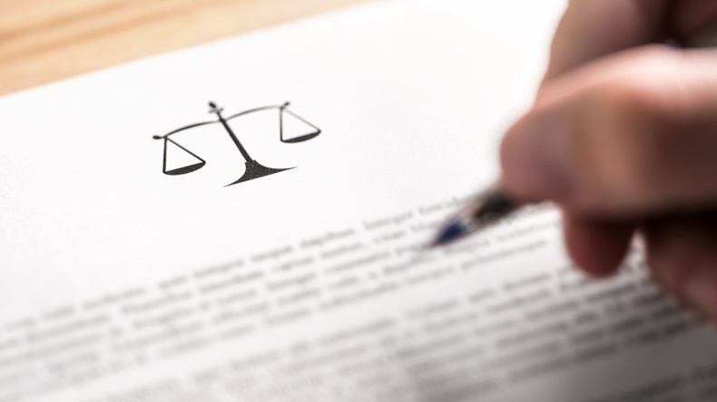 Attorney, lawyer, solicitor or jurist working on a business brief in law firm. Legal contract, clause or article paper. Man writing document with scale icon and sign with pen. Judge making decision.