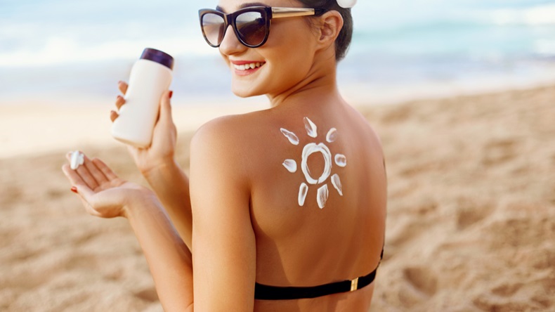 Woman apply Sun cream on tanned back. Skin and Body Care. Sun protection. Portrait of Female in Bikini applying moisturizing sunscreen lotion and Sunblock. Girl Holding Suntan Lotion. - Image 