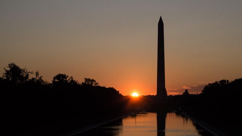 Sun low in the sky over the Washington Monument and Reflecting Pool