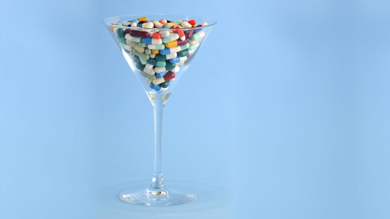 colorful pills and tablets in cocktail glass isolated in blue background - Image 