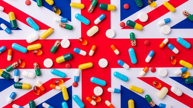 Plenty of capsules and pills laying on a flag of Great Britain