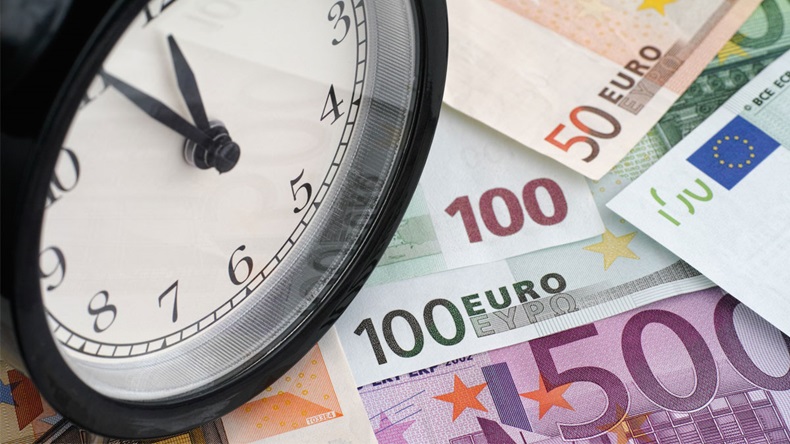 Time is money. Alarm clock and euro banknotes.