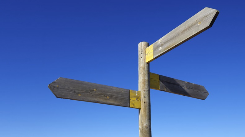 view of three wooden directional signs on a pole - Image