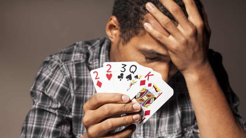 young man shows bad poker cards